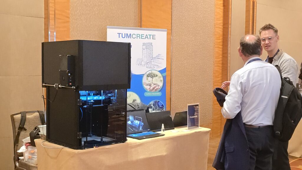 Visitors at the TUMCREATE booth with the gantry-based 3D food printer